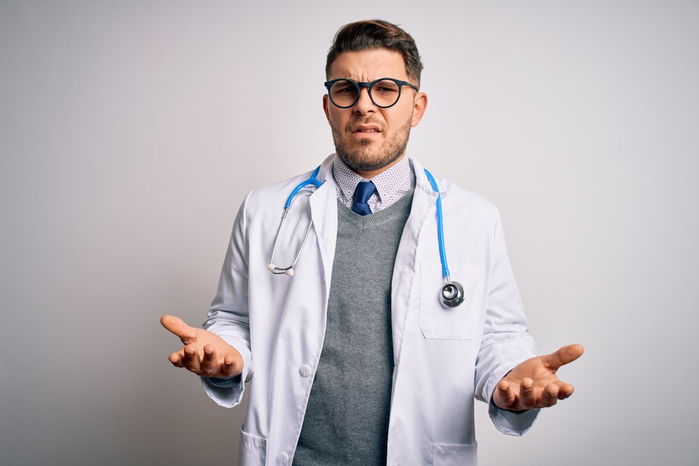Young,Doctor,Man,With,Blue,Eyes,Wearing,Medical,Coat,And